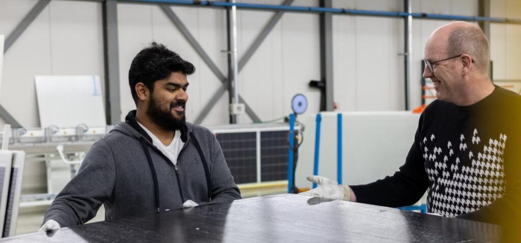 2 mannen met een stuk plaatmateriaal in een werkplaats