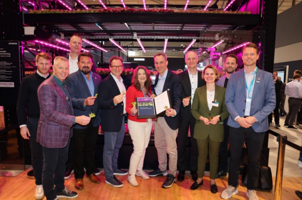 Dirk De Bilde, ceo Siemens Nederland (vierde van rechts) en in het midden Tisha Livingston (ceo Infinite Acres) en Cedrik Neike (board member Siemens AG en ceo Digital Industries) na de ondertekening van de MoU op de Hannover Messe.